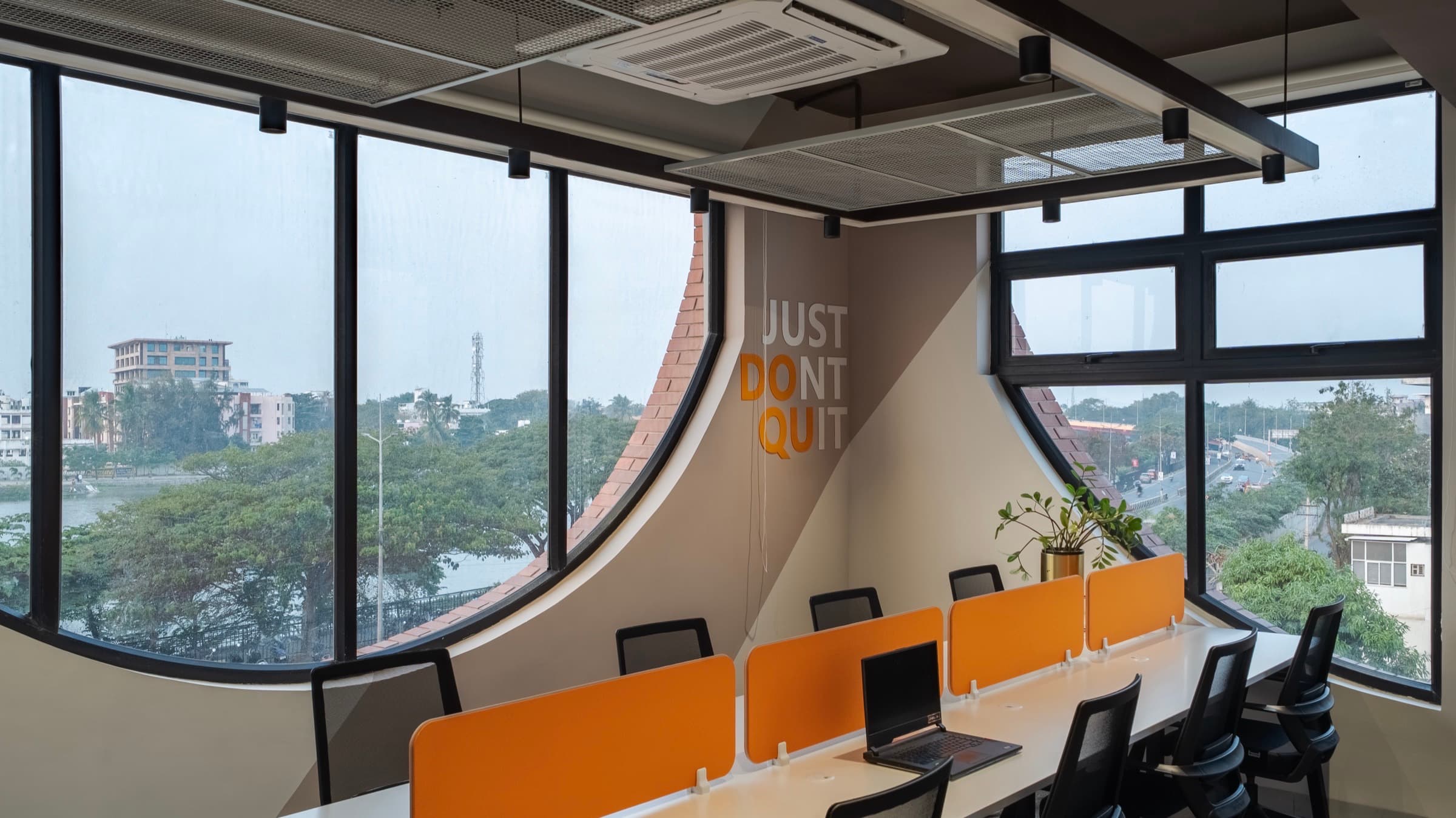 Just Dont Quit mural between curved lake-view windows in the 12 seater lake view private office at Fliqzo Coimbatore