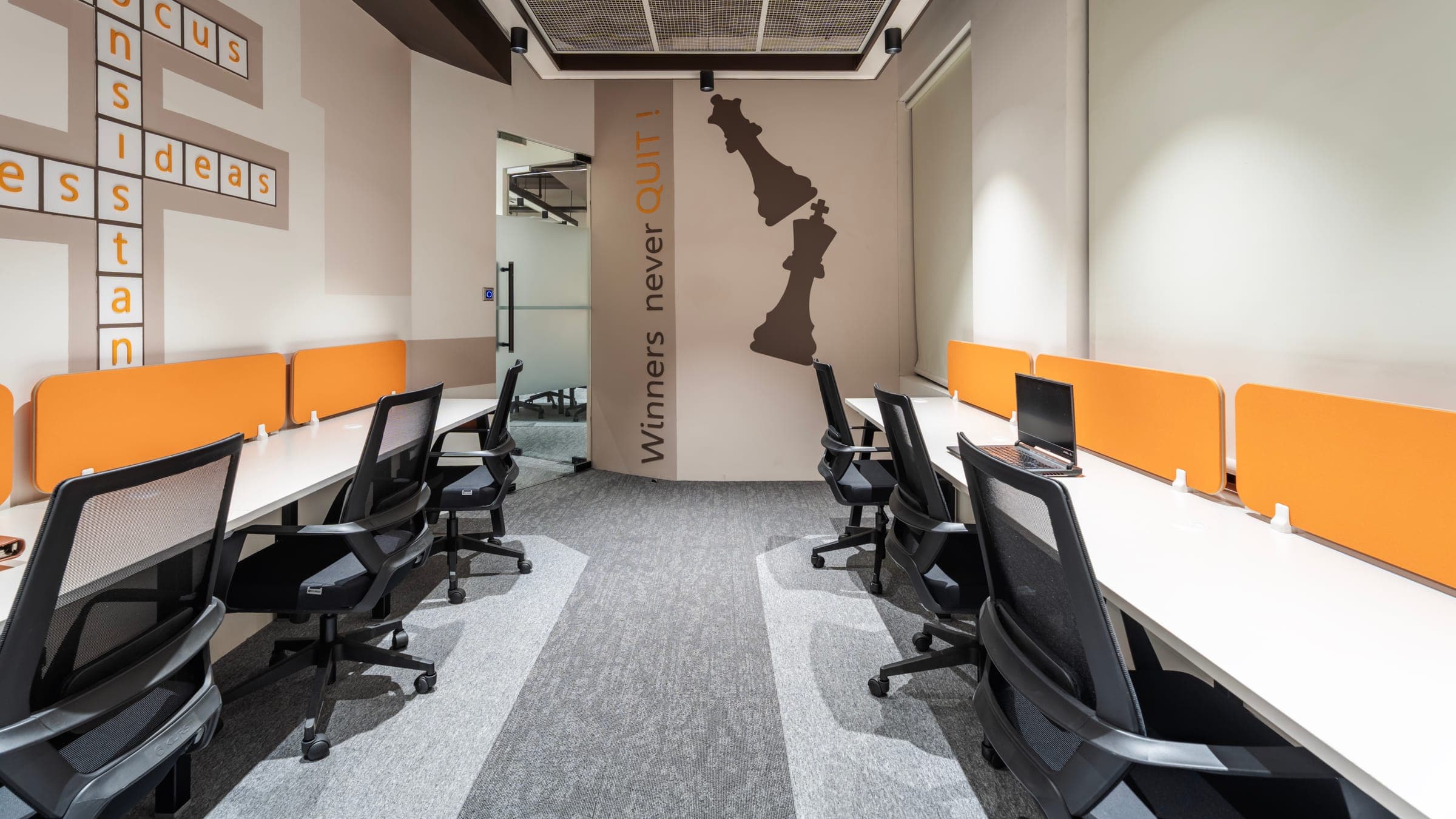 Winners Never Quit chess mural between the desk rows of the 8 seater private office at Fliqzo Coimbatore
